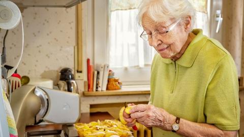 Bild Frau schält Kartoffeln